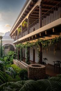 un edificio con balcón y un patio con plantas en Hotel Boutique Los Pasos & Spa, en Antigua Guatemala