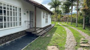 Casa blanca con porche y ventana en Hostal Vallegrande en Rionegro