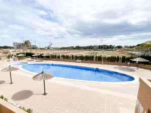 duży basen z parasolami na patio w obiekcie Jardines al Mar piscina y garaje w mieście Oropesa del Mar