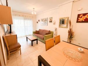 salon z kanapą i stołem w obiekcie Jardines al Mar piscina y garaje w mieście Oropesa del Mar
