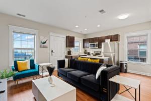 un soggiorno con divano nero e una cucina di Your Cozy One Bedroom Midtown a Detroit