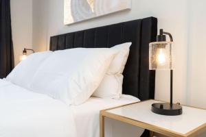 un letto con testata nera e un tavolo con una lampada di Your Cozy One Bedroom Midtown a Detroit