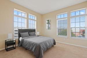 a bedroom with a large bed and windows at Your Summer Get Away with GYM in Indianapolis