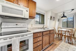 a kitchen with white appliances and a dining room at Hemlock Hideout in Banner Elk