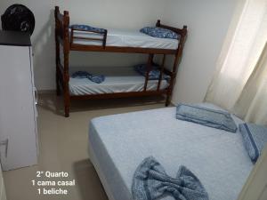 a room with two beds and a couple of bunk beds at Casa em Itajaí Balneário Camboriú e Parque Beto Carrero in Itajaí