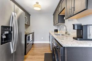 uma cozinha com um frigorífico em aço inoxidável e pisos em madeira em Your Cozy One Bedroom Midtown em Detroit
