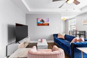 sala de estar con sofá azul y TV en Your Cozy One Bedroom Midtown, en Detroit