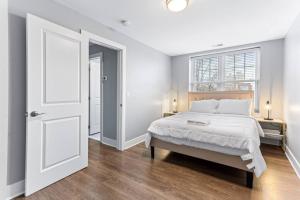 een witte slaapkamer met een bed en een raam bij Your Cozy One Bedroom Midtown in Detroit