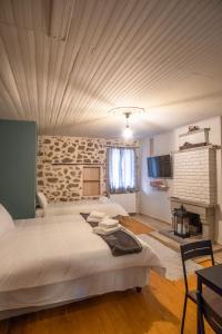 1 dormitorio con 2 camas y pared de piedra en το σπίτι του δάσκαλου- teacher's house, en Sirako