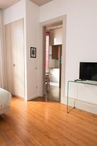 - un salon avec une télévision et du parquet dans l'établissement Santo da Casa / Sc apartments, à Porto
