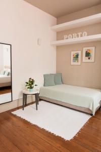 a bedroom with a bed and a table and a mirror at Santo da Casa / Sc apartments in Porto