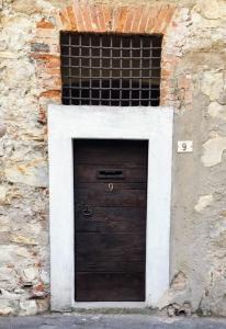 een deur in een stenen gebouw met een stenen muur bij Corte del Cedro in Provaglio d'Iseo