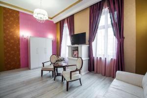 a living room with a couch and a table with chairs at Apartament La Teatru Boudoir in Oradea