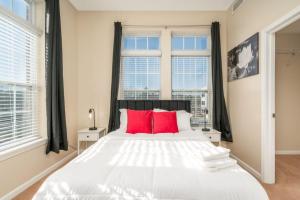 a bedroom with a large white bed with red pillows at Private Bed Downtown INDY - Shared in Indianapolis