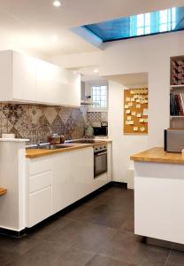 a kitchen with white cabinets and a blue ceiling at Casa del Moro - romantic loft in Trastevere in Rome