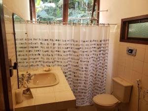 a bathroom with a sink and a shower curtain at Casa linda no sítio in Duque de Caxias
