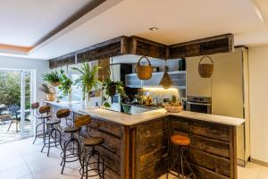 uma cozinha com uma grande ilha de madeira com bancos de bar em Fab's House em Faro