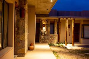 a house with a stone wall and a walkway at Hotel Tulmas in Tilcara