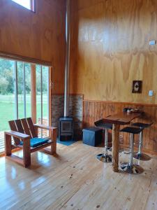 een kamer met een tafel en stoelen en een fornuis bij Cumbres del poicas in Cochamó