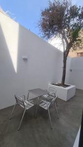 una mesa y dos sillas junto a un árbol en Tia Nita Apartamentos, en Mindelo