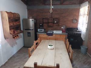 uma cozinha com uma mesa de madeira e um frigorífico em Cabaña en Ayotla Zacatlán Pue em Zacatlán