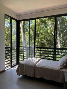 una camera con letto e ampie vetrate di Green house a Florianópolis
