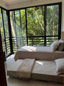 2 letti in una camera con una grande finestra di Green house a Florianópolis
