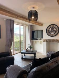 a living room with a couch and a table at Mia Cottage in Keighley