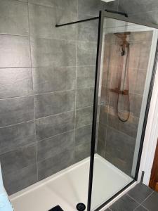 a shower with a glass door in a bathroom at Mia Cottage in Keighley