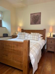 a bedroom with a large wooden bed with white pillows at Mia Cottage in Keighley