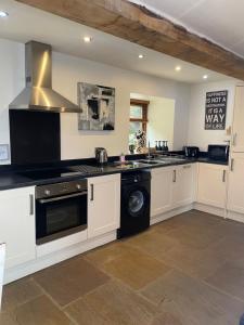 a kitchen with a stove and a dishwasher at Mia Cottage in Keighley