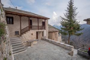 un edificio con un banco delante de él en το σπίτι του δάσκαλου- teacher's house, en Sirako