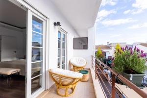 a balcony with a view of a bed and a table at Fab's House in Faro