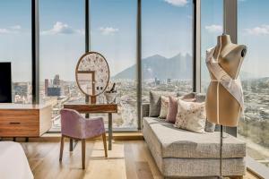 a living room with a couch and a table and a mirror at Fiesta Americana Monterrey Pabellón M. in Monterrey