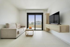 a living room with a couch and a flat screen tv at Premium Apartment with Swimming pool by Aparters in Arenales del Sol