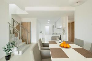 a white kitchen with a table with oranges on it at Premium Apartment with Swimming pool by Aparters in Arenales del Sol