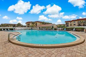 a large swimming pool in a courtyard with buildings at Unit 6302 - Ocean & Racquet Resort in Saint Augustine Beach