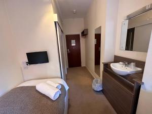 bagno con letto, lavandino e specchio di 281 Hotel & Restaurant a Mansfield