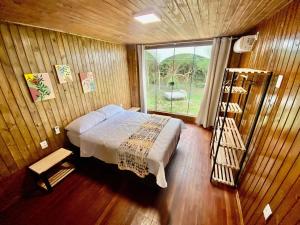 een slaapkamer met een bed in een kamer met een raam bij Lagoa Country Club in Cidreira