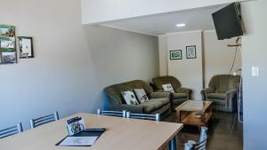 a waiting room with chairs and a table at Departamentos KAYLU in El Bolsón