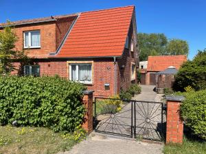 a brick house with an orange roof and a gate at „Grüne Höhle“ in Schwerin in Schwerin