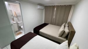 - une petite chambre avec 2 lits et une fenêtre dans l'établissement Apartamento no Centro de Foz do Iguacu, à Foz do Iguaçu
