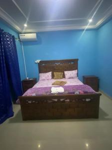 um quarto com uma cama num quarto azul em Appartement Ngor Almadie em Dakar