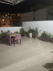 uma mesa e duas cadeiras numa sala com plantas em Appartement Ngor Almadie em Dakar