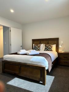 a bedroom with a large bed with two towels on it at Gem in Papanui Christchurch in Christchurch