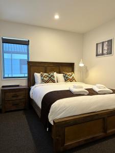 a bedroom with a large bed and a window at Gem in Papanui Christchurch in Christchurch