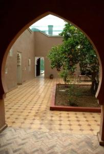 einem Torbogen eines Gebäudes mit einem Baum und einem Innenhof in der Unterkunft RIAD AMINE in Taroudant
