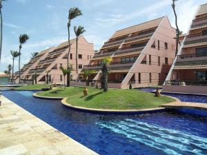 un complejo con piscina y palmeras en Cumbuco Ocean View, en Cumbuco