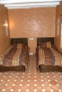 ein Schlafzimmer mit zwei Betten in einem Zimmer in der Unterkunft RIAD AMINE in Taroudant