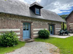 ein Backsteinhaus mit einer blauen Tür und einer Terrasse in der Unterkunft Gîte du « Lavoir » à 2 pas de la mer in Saint-Martin-le-Gaillard